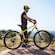 A man standing beside his electronic bike on a mountain in France